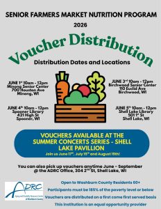 The image is an informational flyer for the “Senior Farmers Market Nutrition Program 2026” highlighting a "Voucher Distribution" event. At the top, bold black text on a light gray background announces the program's name and year. Below, the main heading "Voucher Distribution" is in large green text with curving style. Underneath the heading, in smaller black text, is a subheading reading "Distribution Dates and Locations." The flyer lists specific dates, times, and locations for voucher distribution in black text along both sides of a central image of colorful vegetables, including a carrot, tomato, and greens. The vegetables sit on a stylized wooden table. At the bottom of the flyer, set against a blue oval background, there is text about vouchers available during the summer concerts series at Shell Lake Pavilion. Additional information about the voucher pickup is provided below this, with details on eligibility and the name of the organizing body, ADRC of Washburn County. The ADRC logo is included in the bottom left corner.